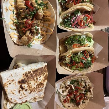 Taco Bamba Springfield - Tacos and a quesadilla - A variety of tacos with different fillings and toppings, along with a quesadilla, are presented in paper trays at Taco Bamba Springfield. - Tacos Near Me - Springfield, Virginia