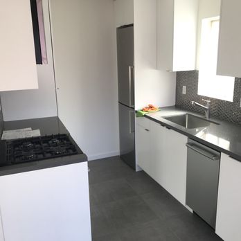 Greenguys Construction - a kitchen with white cabinets and black countertops - General Contractors Near Me - Palm Springs, California Greenguys Construction - a kitchen with white cabinets and black countertops - General Contractors Near Me - Palm Springs, California