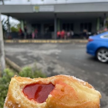 Tex Drive In - a hand holding a donut with a bite taken out of it - Fast Food Near Me - Honokaa, Hawaii