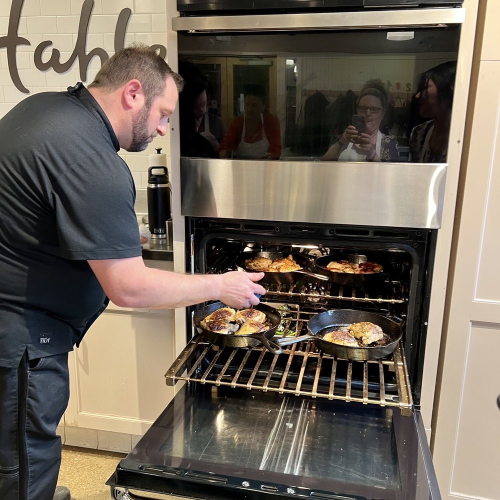 Chef placing our chicken thighs in the oven