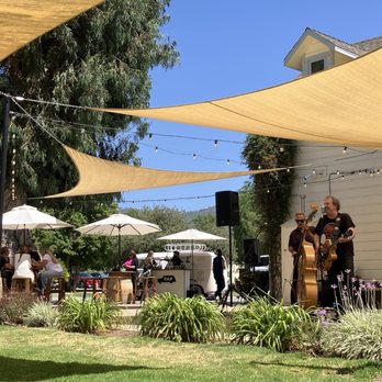 Rancho Guejito Vineyard - Back side of the Farm House, band and dance floor on the patio, small beverage booth in the back by the VW Bus and shade structures. - Wine Tasting Room Near Me - Escondido, California Rancho Guejito Vineyard - Back side of the Farm House, band and dance floor on the patio, small beverage booth in the back by the VW Bus and shade structures. - Wine Tasting Room Near Me - Escondido, California