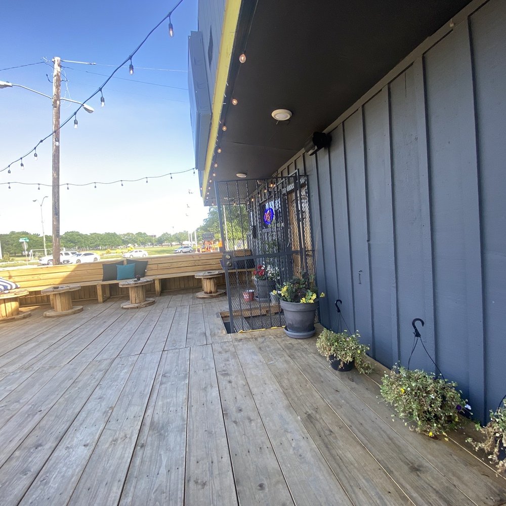 Barfly - a wooden deck with benches and tables - Dive Bars Near Me - Dallas, Texas