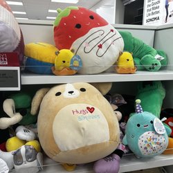 Kohl's - A bunch of squishmallows next to a sign that says 'Buy One Get One 1/2 Off'.