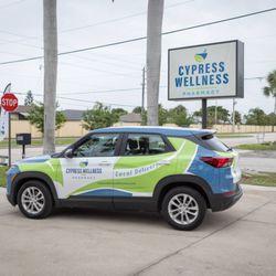Cypress Wellness Pharmacy - Delivery vehicle in front of road sign.