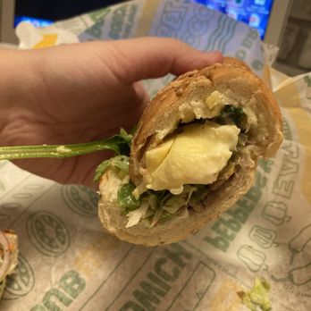 Subway - a hand holding a half eaten sandwich - Fast Food Near Me - New Minas, Nova Scotia