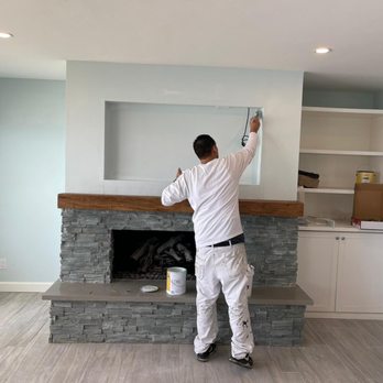 DJ Val Paint and Repair - a man painting a fireplace - Painters Near Me DJ Val Paint and Repair - a man painting a fireplace - Painters Near Me