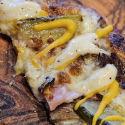 Bobby's Hot And Cheesy - Close-up of the Cuban Pizza with the wood dish.