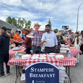 Power Properties - Two Property Managers at Power Properties handing out pancakes at their annual Calgary Stampede Pancake Breakfast - Property Management Near Me - Calgary, Alberta Power Properties - Two Property Managers at Power Properties handing out pancakes at their annual Calgary Stampede Pancake Breakfast - Property Management Near Me - Calgary, Alberta