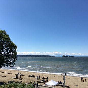 Third Beach - The sandy beach has logs that serve as seating or a place to lean against. - Beaches Near Me - Vancouver, British Columbia