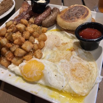 Cincinnati Lager House - Brunch with eggs over easy, fried potatoes, sausage, bacon, English muffin and goetta. - New American Near Me - Cincinnati, Ohio Cincinnati Lager House - Brunch with eggs over easy, fried potatoes, sausage, bacon, English muffin and goetta. - New American Near Me - Cincinnati, Ohio