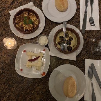 Costa Brava - Table spread (clockwise from the top right)    Bread roll  Caracoles al Ali-Oli  Queso Manchego  Patatas A La Brava - Tapas Bars Near Me - San Diego, California