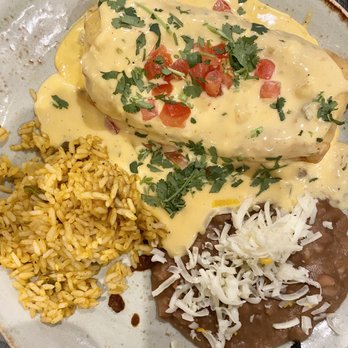 Cantina Laredo - Chicken Chimichanga with rice and beans topped off with cheddar cheese sauce. - Mexican Near Me - Virginia Beach, Virginia Cantina Laredo - Chicken Chimichanga with rice and beans topped off with cheddar cheese sauce. - Mexican Near Me - Virginia Beach, Virginia