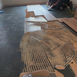 West Coast Floor Company - Installation in progress. Subfloor prepped, roll on moisture barrier and glue down install...