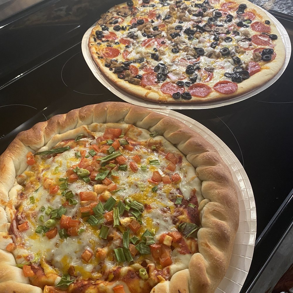 two pizzas on a stove