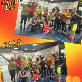 Open Mat Academy - Zumba at Open Mat with ZIN Felicia - A group of people, dressed in bright and comfortable workout clothing, are gathered inside a fitness studio at Open Mat Academy in Tracy, CA. They are posing for photos, some making heart shapes with their hands and others raising their arms in celebration. The background shows exercise equipment and a mirrored wall, indicating a fitness or dance class setting. The image is decorated with a vibrant orange and yellow border, with the words "Zumba" and "Tracy" written in stylized fonts, emphasizing the activity and location. - Boxing Near Me - Tracy, California