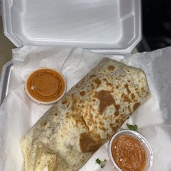 Big burrito with steak, cheese, beans, rice, tomatoes, lettuce, cilantro, onions and red sauce.