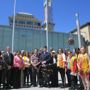 Celebration Square - Representatives from municipal, provincial and federal government with volunteers during the 100th Lions anniversary flag raising at C.S. - Parks Near Me - Mississauga, Ontario