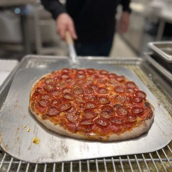 OG ZaZa Pizza & Catering - ROSEVILLE - a person preparing a pizza - Pizza Near Me - Roseville, Minnesota OG ZaZa Pizza & Catering - ROSEVILLE - a person preparing a pizza - Pizza Near Me - Roseville, Minnesota