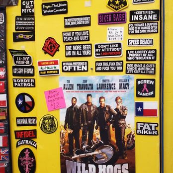 Maggie's Diner - The image shows a yellow surface decorated with stickers, signs, and a movie poster for 'Wild Hogs,' including humorous and political messages, along with a pink note for a movie poster price. - Souvenir Shops Near Me - Madrid, New Mexico