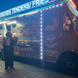 a man and woman standing in front of a food truck a man and woman standing in front of a food truck
