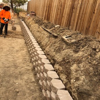 Specialty Builders - a man working on a retaining wall - General Contractors Near Me