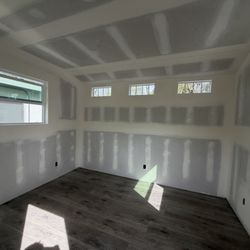 Insulation and drywall work in a 12' x 10' shed with an angled ceiling.