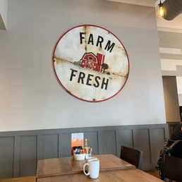 a table with a cup of coffee and a sign that says farm fresh