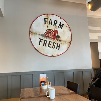 First Watch - a table with a cup of coffee and a sign that says farm fresh - Breakfast & Brunch Near Me - Oviedo, Florida