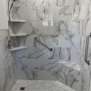 Precise Remodeling - a bathroom with a marble shower - Painters Near Me
