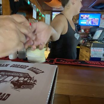Mill Dam Corner Grille - a woman serving a pizza - American Near Me - Hebron, Ohio