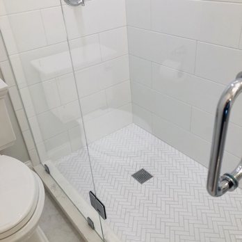 Eric Construction - Walk-in glass shower, herringbone tiled floor. - General Contractors Near Me