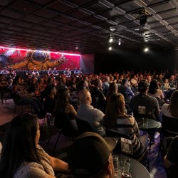 Audience members attend a live stand-up comedy performance during the opening weekend at The Riot Comedy Club's new location ...