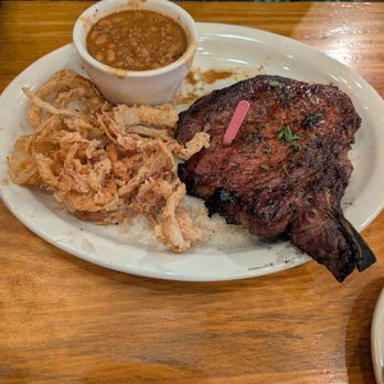 Bama Bucks - The 35 day dry aged split bone ribeye with onion rings and baked beans! 10/10 perfection! - New American Near Me - Sardis City, Alabama Bama Bucks - The 35 day dry aged split bone ribeye with onion rings and baked beans! 10/10 perfection! - New American Near Me - Sardis City, Alabama
