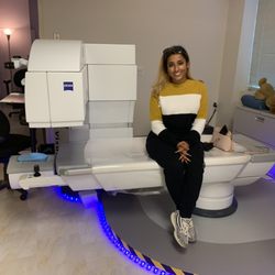 Photo of Manhattan Lasik Center - New York - New York, NY, US. SMILE patient Sara poses with the ZEISS VisuMax technology