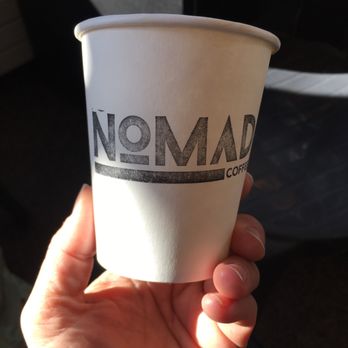 Nomad Coffee - a hand holding a paper cup - Coffee & Tea Near Me - Warren, Vermont