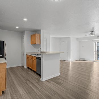 Eagles Landing Apartments - View of expansive living room and kitchen area with plank flooring, natural light, and a sliding glass dooes that lead to a p... - Apartments Near Me - Ammon, Idaho Eagles Landing Apartments - View of expansive living room and kitchen area with plank flooring, natural light, and a sliding glass dooes that lead to a p... - Apartments Near Me - Ammon, Idaho