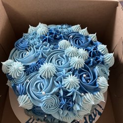 Chocolate Cake with Buttercream Frosting in the middle. Covered in Blue Roses.