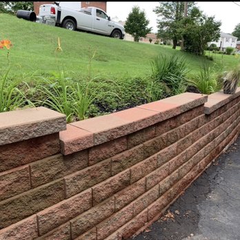 NLC Landscaping - a brick retaining wall along a street - Lawn Services Near Me NLC Landscaping - a brick retaining wall along a street - Lawn Services Near Me