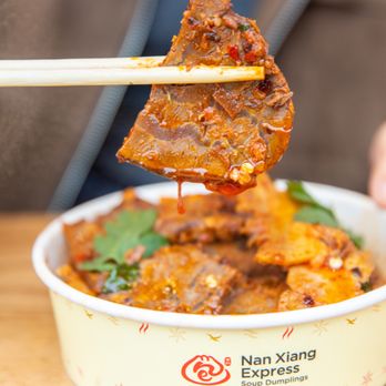 Nan Xiang Express - person holding chopsticks above a bowl of food - Shanghainese Near Me - Boston, Massachusetts Nan Xiang Express - person holding chopsticks above a bowl of food - Shanghainese Near Me - Boston, Massachusetts