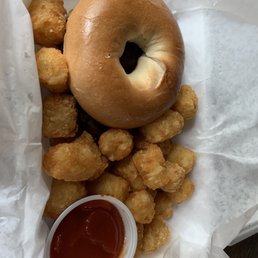 Well done bacon, egg and cheese bagel with tator tots.