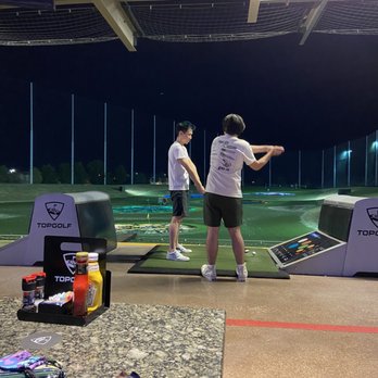 Topgolf - Son giving lesson to son. - Golf Near Me - Allen, Texas Topgolf - Son giving lesson to son. - Golf Near Me - Allen, Texas