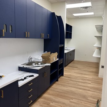 Fischer Built - a kitchen with blue cabinets and white countertops - General Contractors Near Me