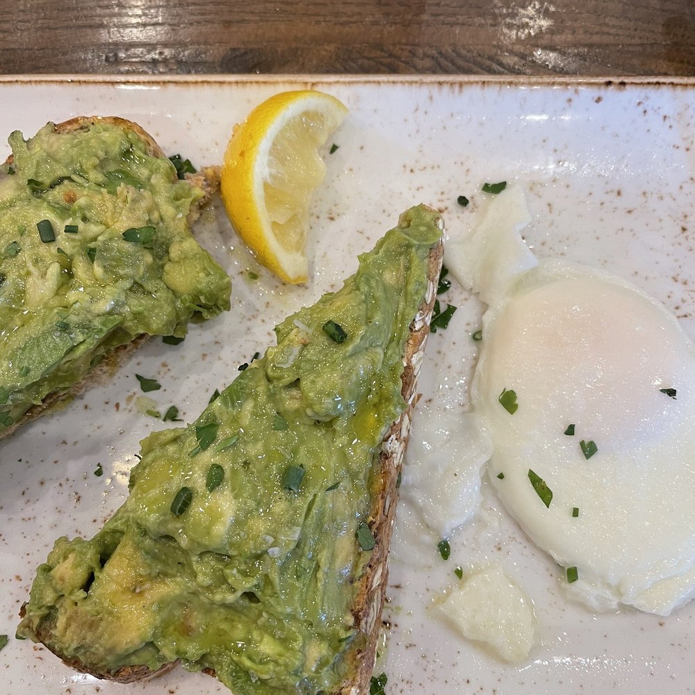 Avocado toast on multi grain bread with poached eggs on the side