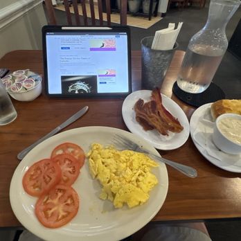 Egg It On Cafe - Eggs and sliced tomatoes with a side of bacon and a biscuit and gravy. - Breakfast & Brunch Near Me - Broken Arrow, Oklahoma
