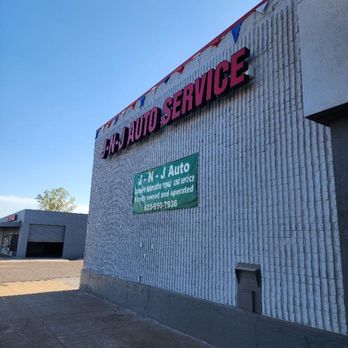 J-N-J Auto Service - A wide shot of an auto service shop's exterior on a sunny day, featuring a prominent "N-J AUTO SERVICE" sign in pink and red,... - Auto Repair Near Me - Phoenix, Arizona