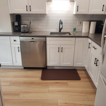 Idr Construction - a kitchen with white cabinets and stainless steel appliances - Roofing Near Me
