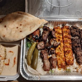 Crown Restaurant - Mashwai combo for two people to go - A takeout meal featuring grilled meats, rice, naan bread, and dips, served in a metal tray with side containers, representing Middle Eastern cuisine. - Mediterranean Near Me - Phoenix, Arizona