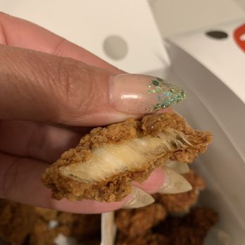 Bonchon Reston - a hand holding a piece of fried food - Korean Near Me - Reston, Virginia