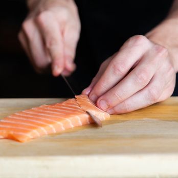 Satori Sushi - a person cutting a piece of salmon - Sushi Bars Near Me - Saint-Jean-sur-Richelieu, Quebec Satori Sushi - a person cutting a piece of salmon - Sushi Bars Near Me - Saint-Jean-sur-Richelieu, Quebec
