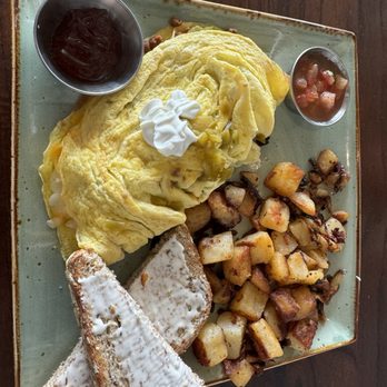 First Watch - Chorizo green chile omelette con pico had some spice in there skillet potatoes and multi grain bread - $13 - Cafes Near Me - Rock Hill, South Carolina